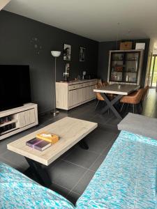 a living room with a couch and a table at Modern Duplex Apartment with terrace view in Stekene