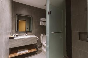 a bathroom with a sink and a toilet and a mirror at Legong Keraton Beach Hotel in Canggu