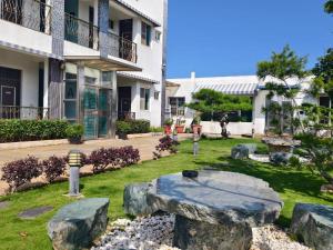a garden with rocks and a stone table in front of a building at 好室行旅House inn 金門大學旁 近市區 in Jinning