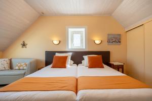 a bedroom with a large bed and a couch at Chambres D'hôtes De Kerantum in Mahalon