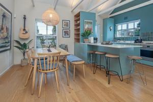 a kitchen with blue walls and a wooden table and chairs at Cosy Cottage Onrus - With Pool in Hermanus