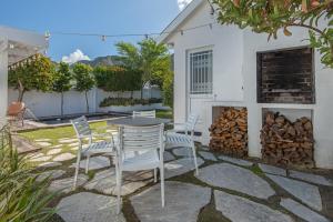 a patio with a table and chairs and a fire place at Cosy Cottage Onrus - With Pool in Hermanus
