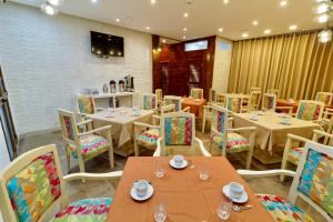 a restaurant with tables and chairs in a room at Hotel Roma in Tunis