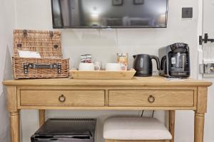 a wooden table with a coffee maker on top of it at Noble Goose Rooms in Coggeshall +36 photos