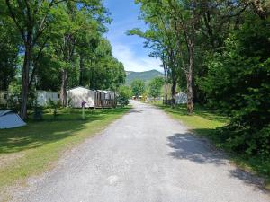 a gravel road with tents and trees on the side at camping de l'or bleu in Barrême