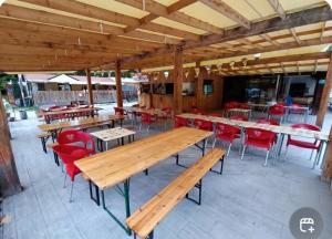 a restaurant with wooden tables and red chairs at camping de l'or bleu in Barrême