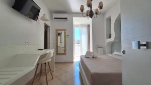 a white room with a bed and a sink at Le Dune Luxury Rooms in Vieste