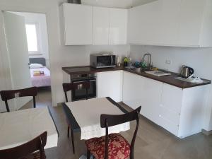 a kitchen with white cabinets and a table and a microwave at L'Acquaviva in Bisceglie
