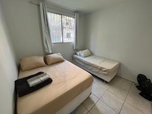 a small bedroom with a bed and a window at Excellent value for money - Fully equipped apartment in Macaé
