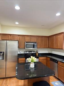 a kitchen with wooden cabinets and stainless steel appliances at Joykip's place in West Des Moines
