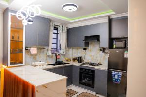 a kitchen with gray cabinets and a black refrigerator at LIBERTY TOWERs in Lower Kabete