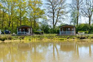 two gazebos next to a body of water at Recreatiepark Goorzicht in Aalten