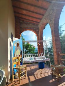 a porch with a swing and a painting at Fonte Degna - Alloggio e Sito Storico in Citerna