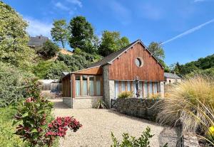 a barn style house with a stone wall at Quai du Val is a Charming Pet and Family Friendly Riverside Gite in Lehon close to Dinan Sleeps 7 in Dinan
