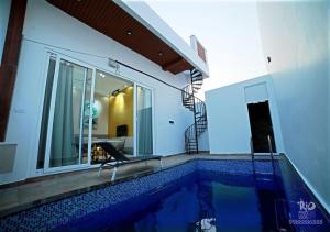a swimming pool with a chair next to a house at RIO POOL VILLAS in Chīrāla