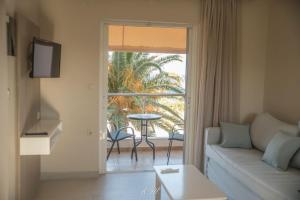 a living room with a couch and a view of a patio at Flisvos Rooms in Palaiochora