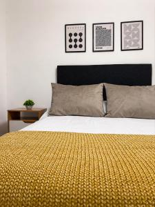 a bedroom with a bed with a yellow blanket on it at Paramont Rosario 4 in Rosario de la Frontera