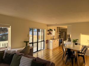 a living room with a couch and a table at Waikanae Beach Abode in Waikanae