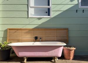 a pink bath tub sitting in front of a building at Waikanae Beach Abode in Waikanae +25 photos