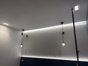 a room with three lights on a white wall at Angelica Suites Keramoti Area in Keramoti