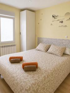 a bedroom with a large bed with two pillows at Apartamento de 2 dormitorios en el centro de Burgos junto a la Catedral in Burgos