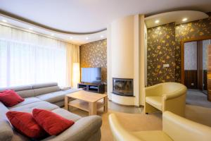 a living room with a couch and a tv at Apartmán Bílá Hora - Plzeň in Pilsen