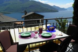 a table with plates and wine glasses on a balcony at Amarone Classica in Gravedona