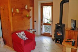 a living room with a red chair and a wood stove at Amarone Classica in Gravedona +22 photos