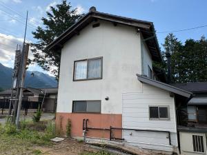 a white house with windows and mountains in the background at 一棟貸しの宿 餓鬼大将と別館トキワ荘 in Omachi +41 photos