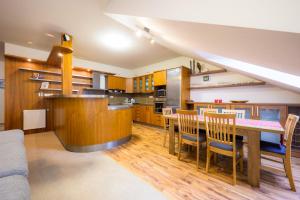 a kitchen with a table and chairs in a room at Apartmán Bílá Hora - Plzeň in Pilsen