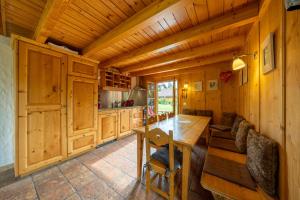a kitchen with a wooden table and a dining room at Chalet Pierre Blanche in Nendaz