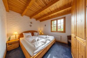 a bedroom with a large bed and a wooden ceiling at Chalet Pierre Blanche in Nendaz