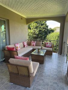 a patio with couches and tables on a balcony at Eastview Guest House in Harare