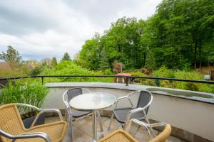 a patio with chairs and a table on a balcony at Apartmán Bílá Hora - Plzeň in Pilsen