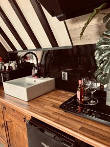 a kitchen with a sink and a counter with wine glasses at Slapen bij Café de Concurrent in Vlissingen +32 photos