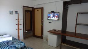 a room with a bedroom with a bed and a tv at Apartamento Rio Preguiças in Barreirinhas