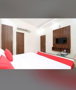 a bedroom with a bed and a flat screen tv at FB Hotel in Kharar