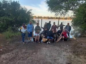 a group of people posing for a picture next to a lake at Muke Village Guest House in Livingstone