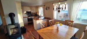 a kitchen and dining room with a wooden table and a stove at Apartment Solbakken Feriehus in Fevåg