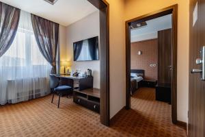 a hotel room with a mirror and a desk at INTER BUSINESS Bucharest in Bucharest