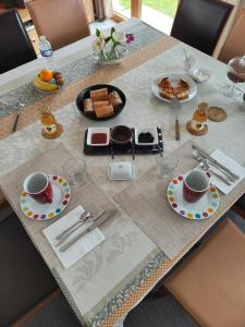 a table with plates of food and cups on it at LE RUBAN BLEU FACE A LA MER in Arromanches-les-Bains +20 photos