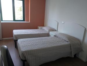 a room with three beds and a window at Viva Campus di GM Industries srl in Ferrazzano