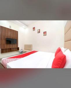 a bedroom with a large bed with red pillows at FB Hotel in Kharar