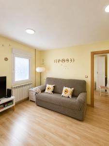 a living room with a couch and a television at Apartamento de 2 dormitorios en el centro de Burgos junto a la Catedral in Burgos