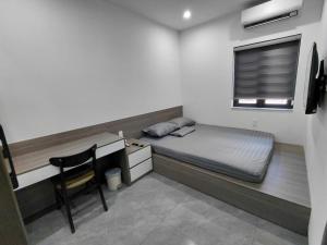 a bedroom with a bed and a desk and a window at ZENITH STAY by Lan's in Danang