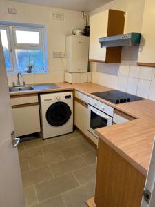 a kitchen with a washing machine and a sink at Kirkar Flat in Penton Mewsey