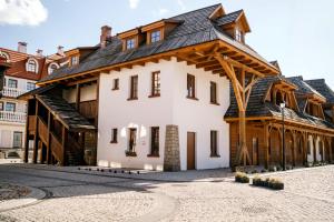 a large wooden house with a black roof at Kresowy View Apartment in Biłgoraj