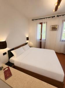 a bedroom with a large white bed and a table at B&B La Vigna dei Fratelli in lido degli scacchi +45 photos