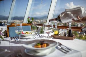 a table with a plate of food and wine glasses at Radon Plaza in Sarajevo