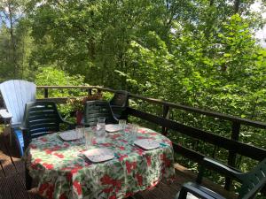 a table on a deck with a table cloth on it at Chalet cosy - terrasse et détente, escapade nature au Bonsoy in Waulsort